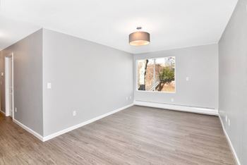 An empty living room with white walls and a window
